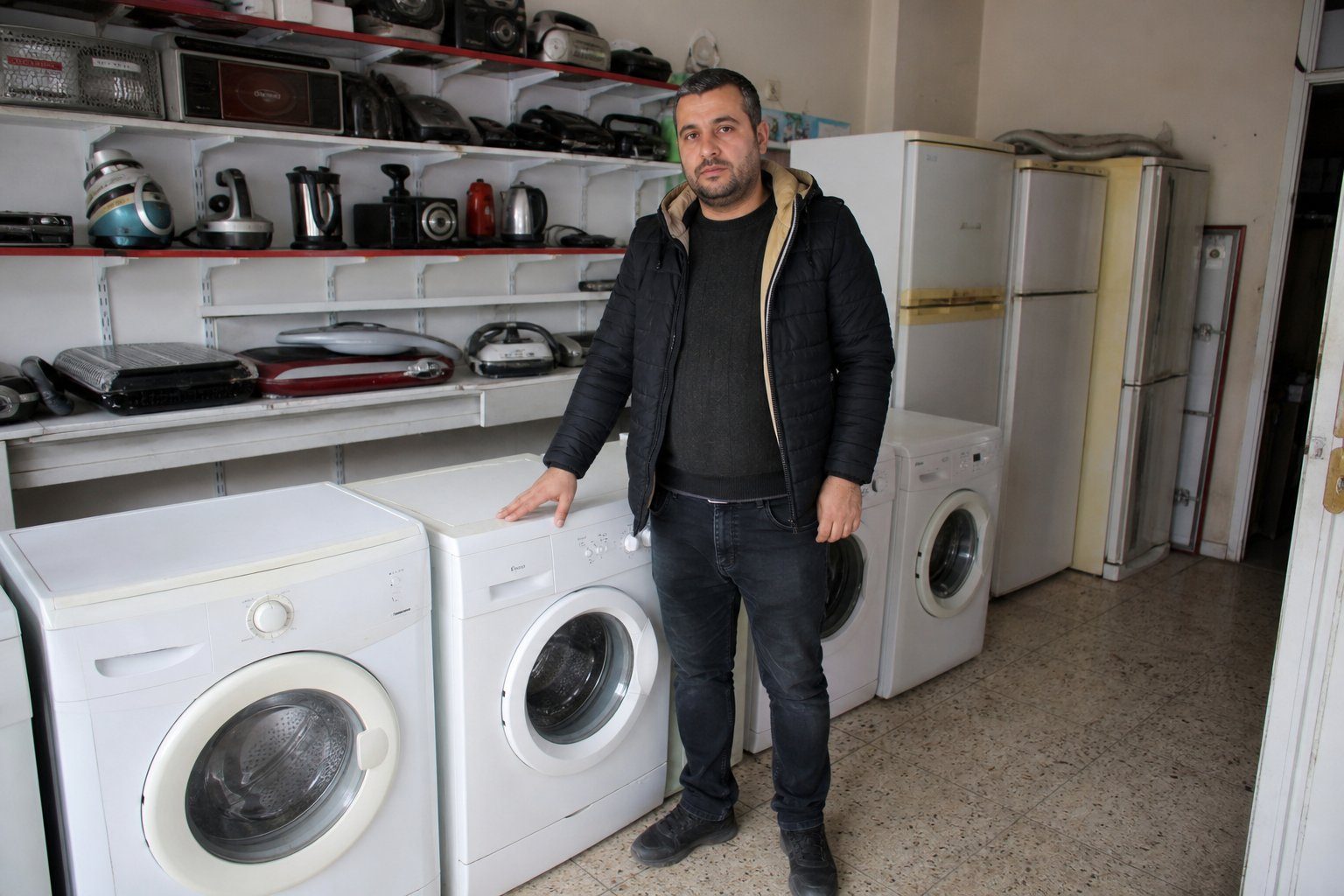 İkinci el beyaz eşya reyonunda ürünleri gösteren satıcı