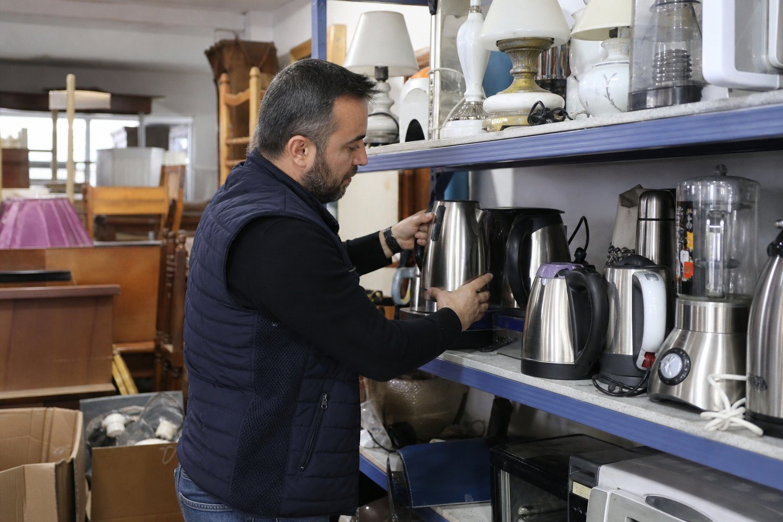 Karma eşya mağazasinda raflari duzelten personel